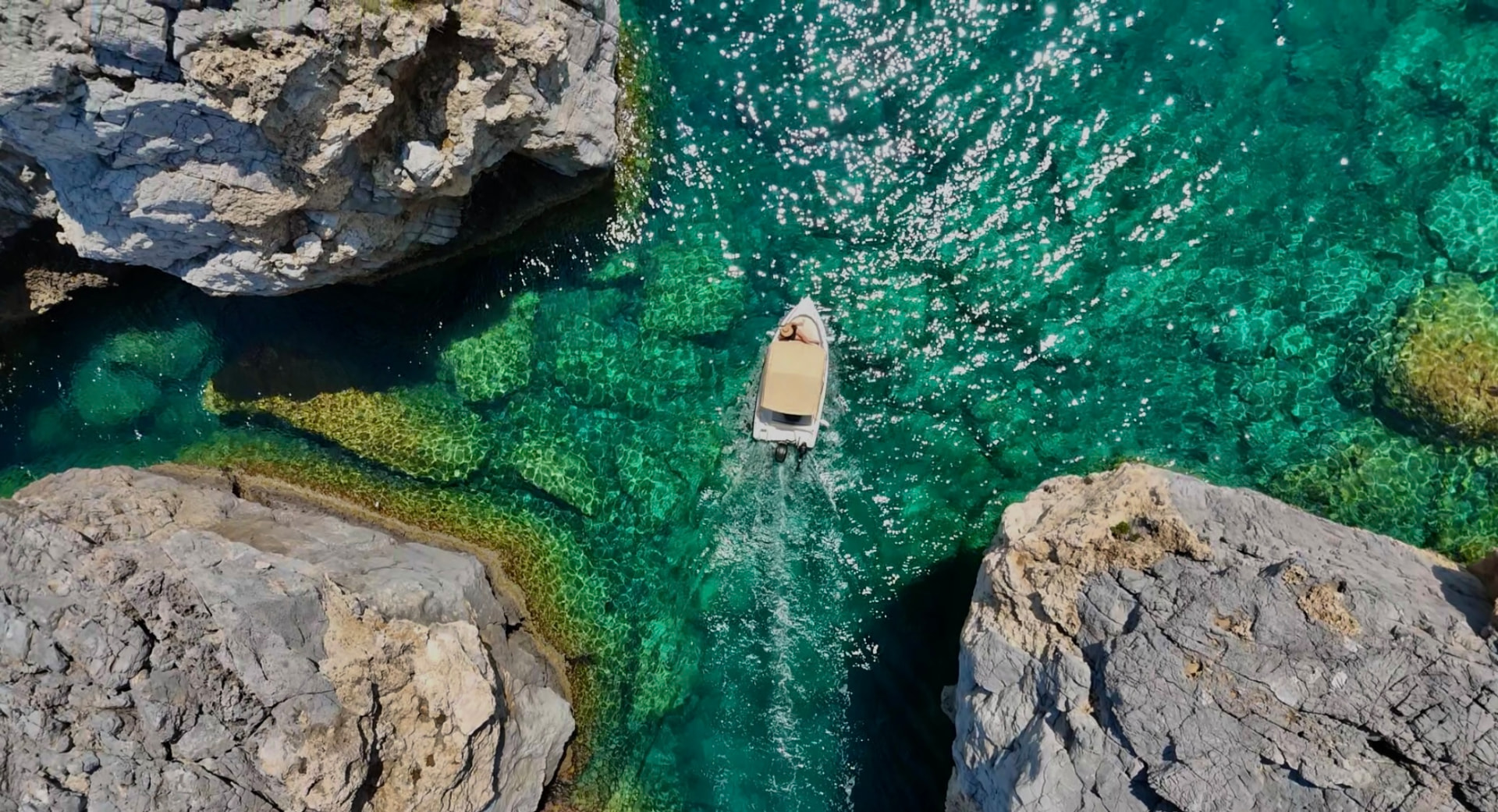 Drone shot of crystal clear green water and hidden coves in Rhodes