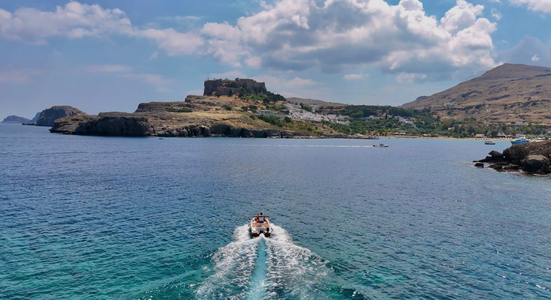 Boat approaching the Acropolis of Lindos from the sea