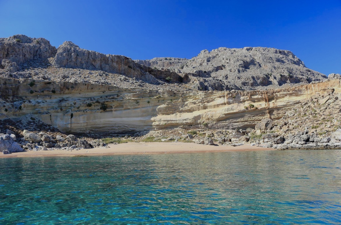 Secluded sandy beach reachable only by boat in Rhodes